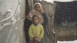 Ein Mädchen mit ihrer Mutter vor ihrem provisorischen Zuhause.