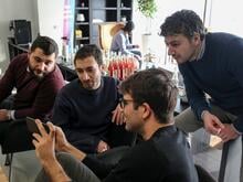 Männliche Teilnehmer des Devugee-Programms in Berlin unterhalten sich.