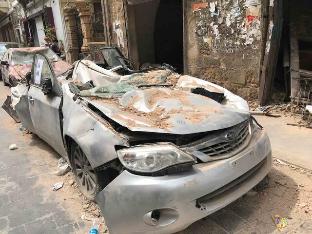 Ein Auto in den Straßen von Beirut ist zerstört und unter Schutt begraben.