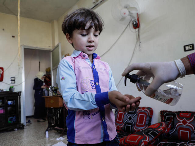 Der fünfjährige Murad aus Syrien desinfiziert seine Hände.