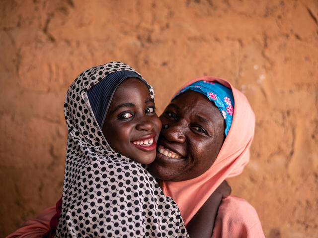Fatima and her mother Habiba hug each other and smile