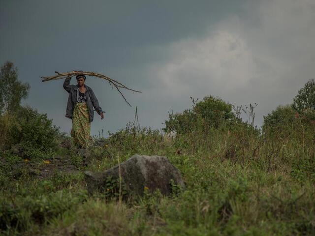 Eine Frau geht über ein Feld in Kongo.