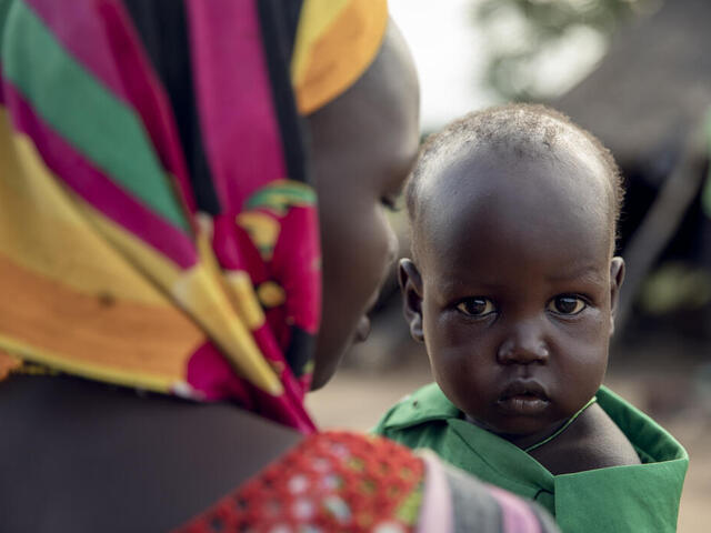 Ein Baby im Arm seiner Mutter in Sued Sudan