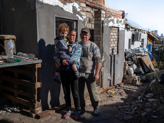 Eine ukrainische Familie steht vor ihrem Haus