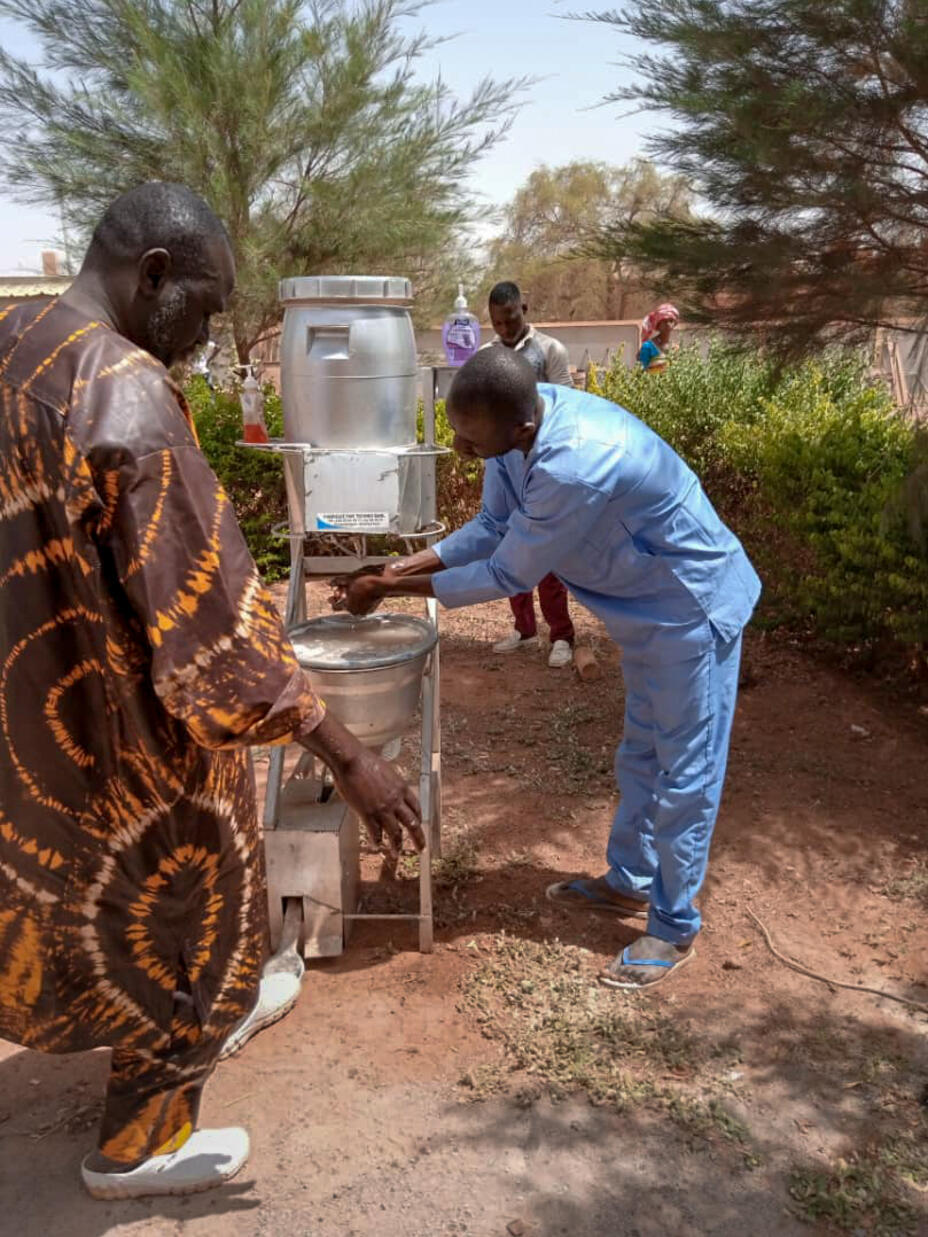 Gesundheitsfachkräfte führen mit Unterstützung von IRC in einem Gesundheitszentrum in Djibo, Burkina Faso, ein Screening auf Symptome des Coronavirus durch.