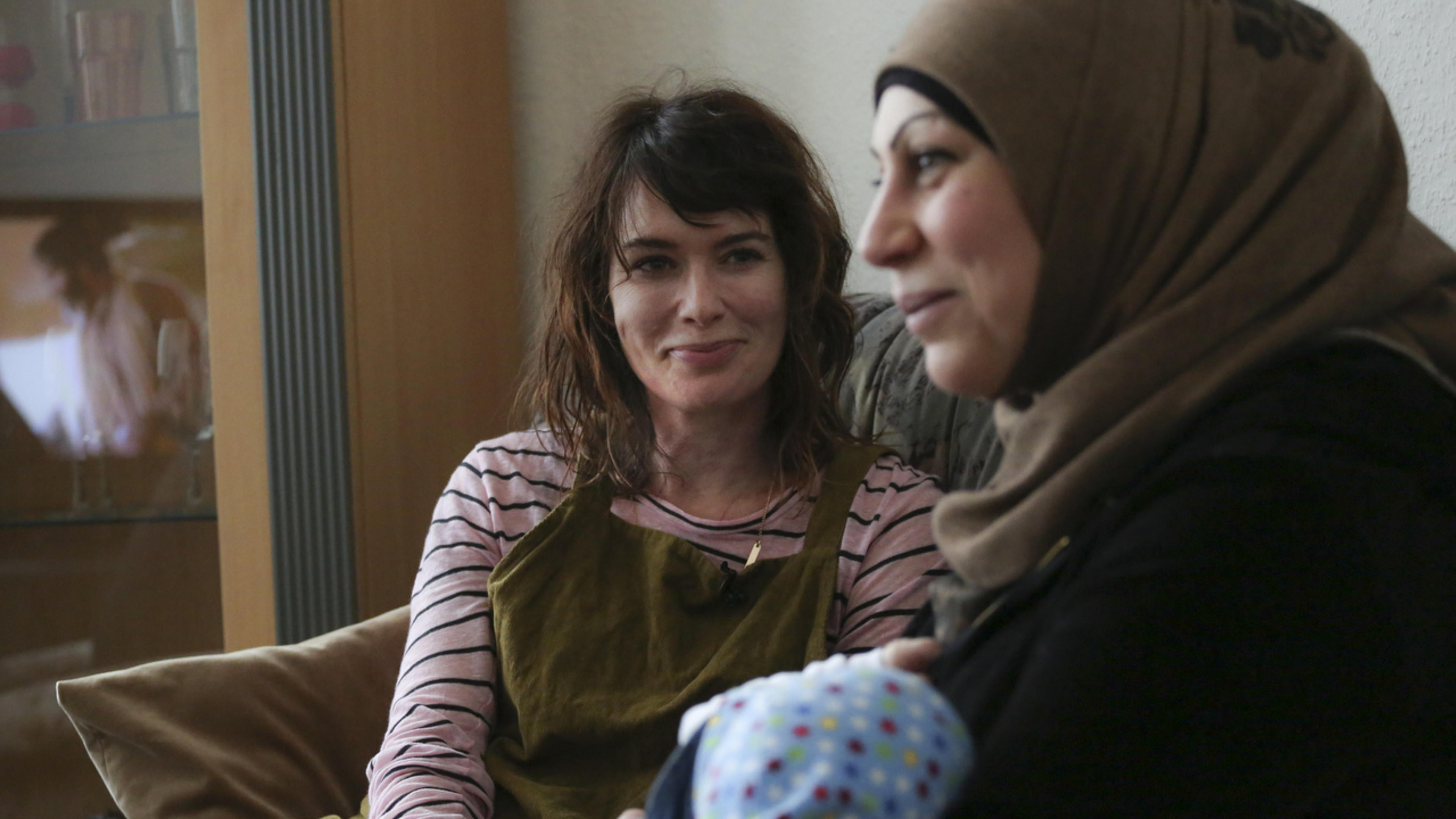 Lena Headey sits with refugees in Germany