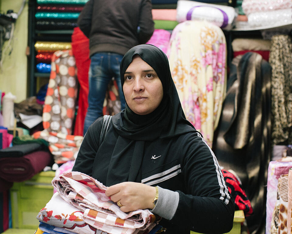 Rehab kauft Stoff auf dem Markt in Amman, Jordanien, ein.