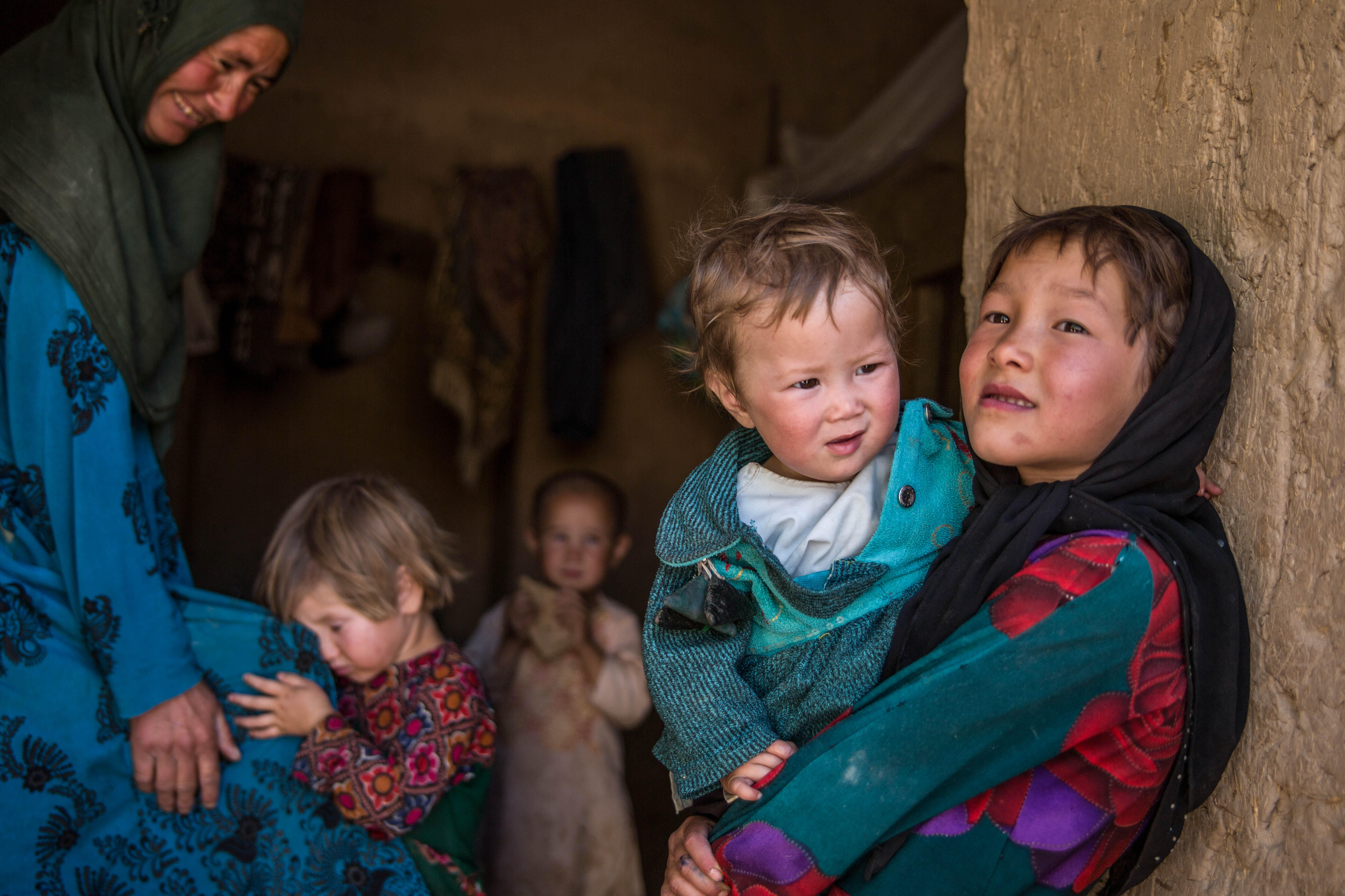 Ett barn håller sitt syskon i armarna i Afghanistan