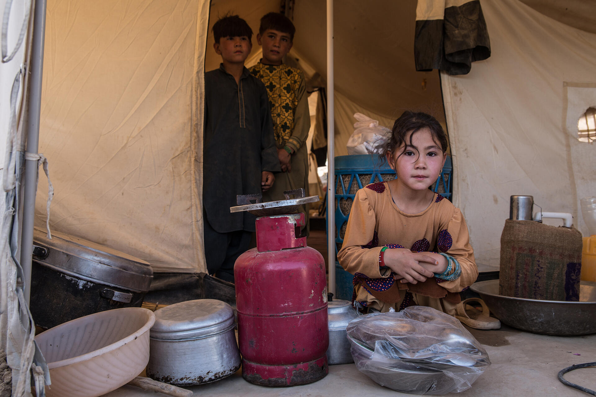 Barn sitter i sitt hem i Afghanistan och tittar in i kameran