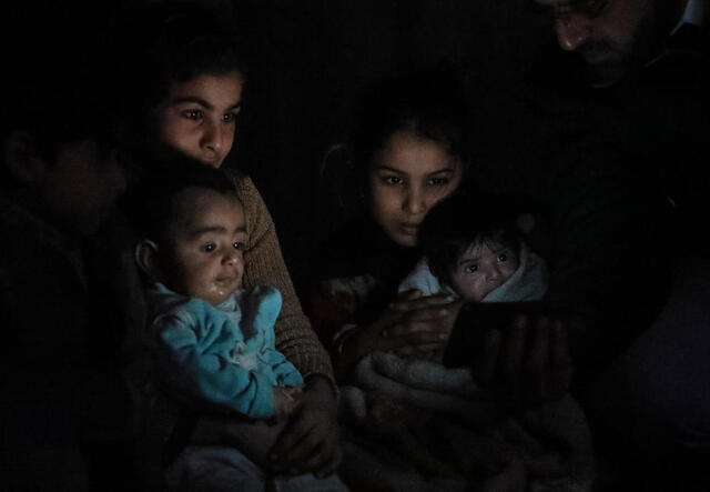 Eine syrische Familie sitzt im dunkeln in Syrien