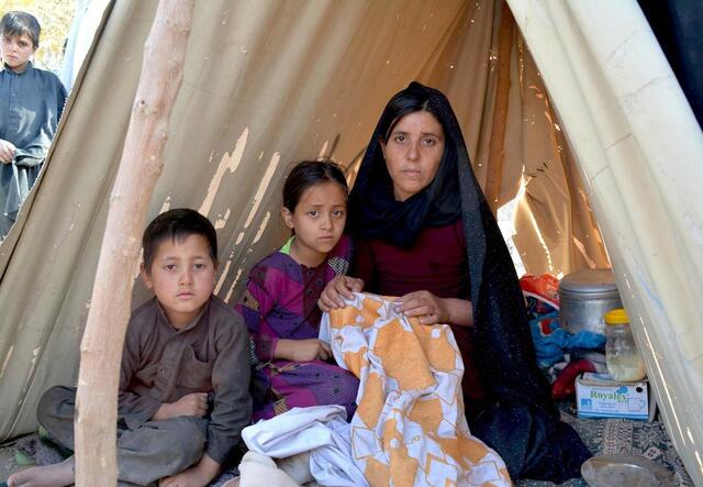 Eine Familie aus Afghanistan sitzt in einem Zelt