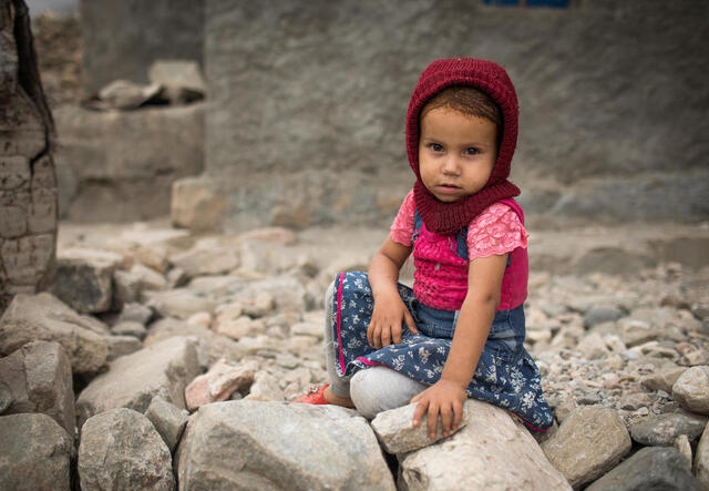 Ein junges Mädchen sitzt in Trümmern