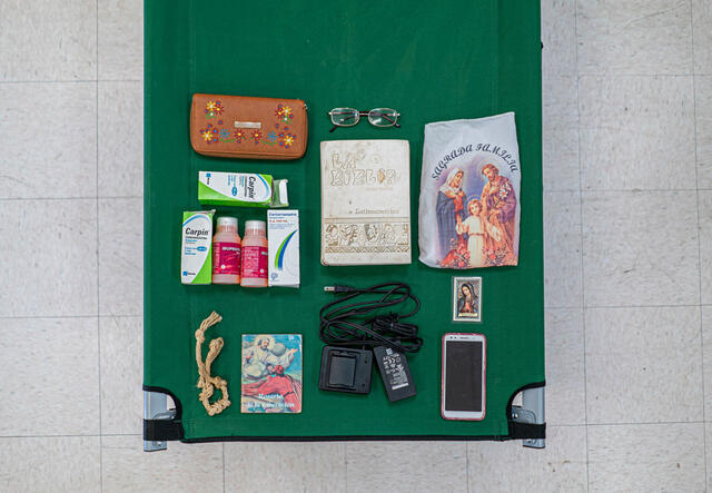 Luisas Habseligkeiten liegen auf einer grünen Trage, Medizin, eine Bibel, ein Rosenkranz, ein Handy und persönliche Unterlagen
