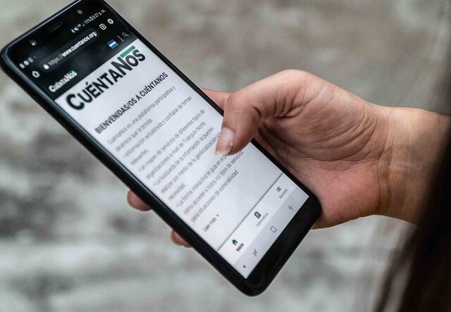 Auf einem Smartphonebildschirm ist die Website des Informationsportals CuéntaNos für Geflüchtete zu sehen