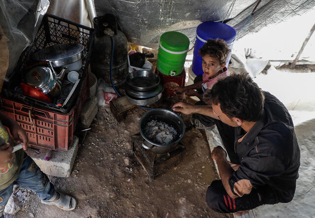 Vater kocht mit seinem Sohn in einem syrischen Flüchtlingslager