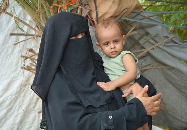 Jemenitische Mutter hält ihr Kind auf dem Arm.