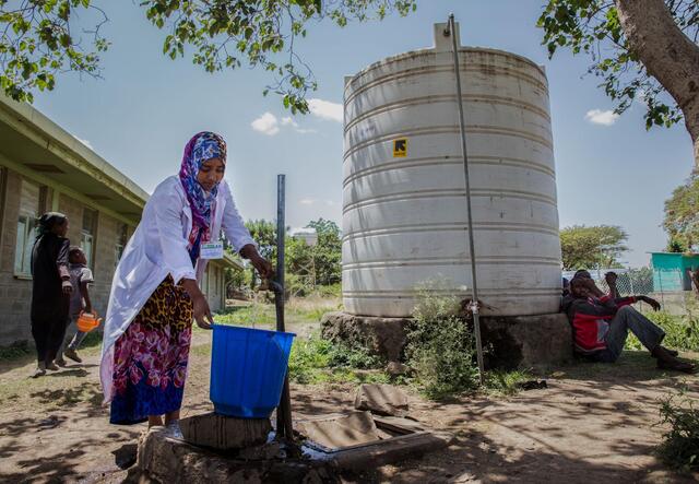 Eine Frau holt Wasser an einer von IRC bereitgestellten Anlage in Äthiopien