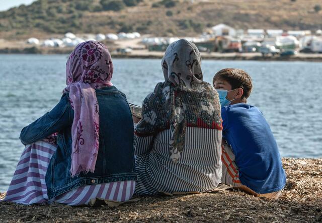 Rahima sitzt mit ihren Kindern zusammen und schaut aufs Meer.