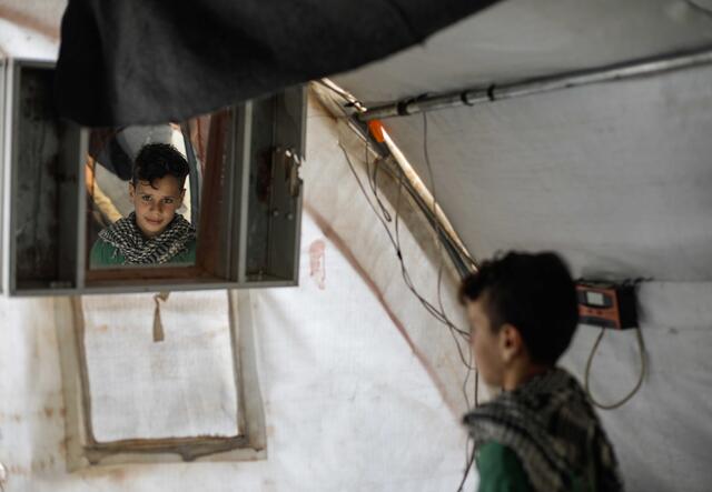 Junge guckt in den Spiegel in einem Zelt