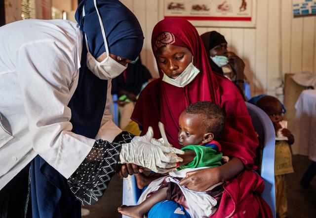 Ein Kind wird auf dem Schoß seiner Mutter untersucht im Arif Gesundheitszentrum in Somalia.