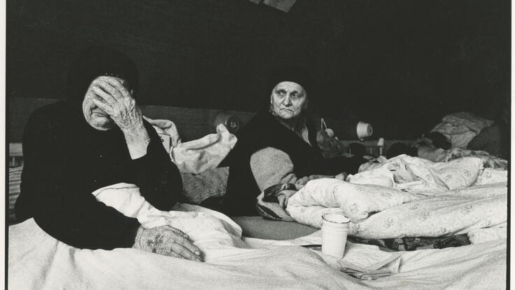 Zwei ältere Frauen sitzen in einem Flüchtlingslager